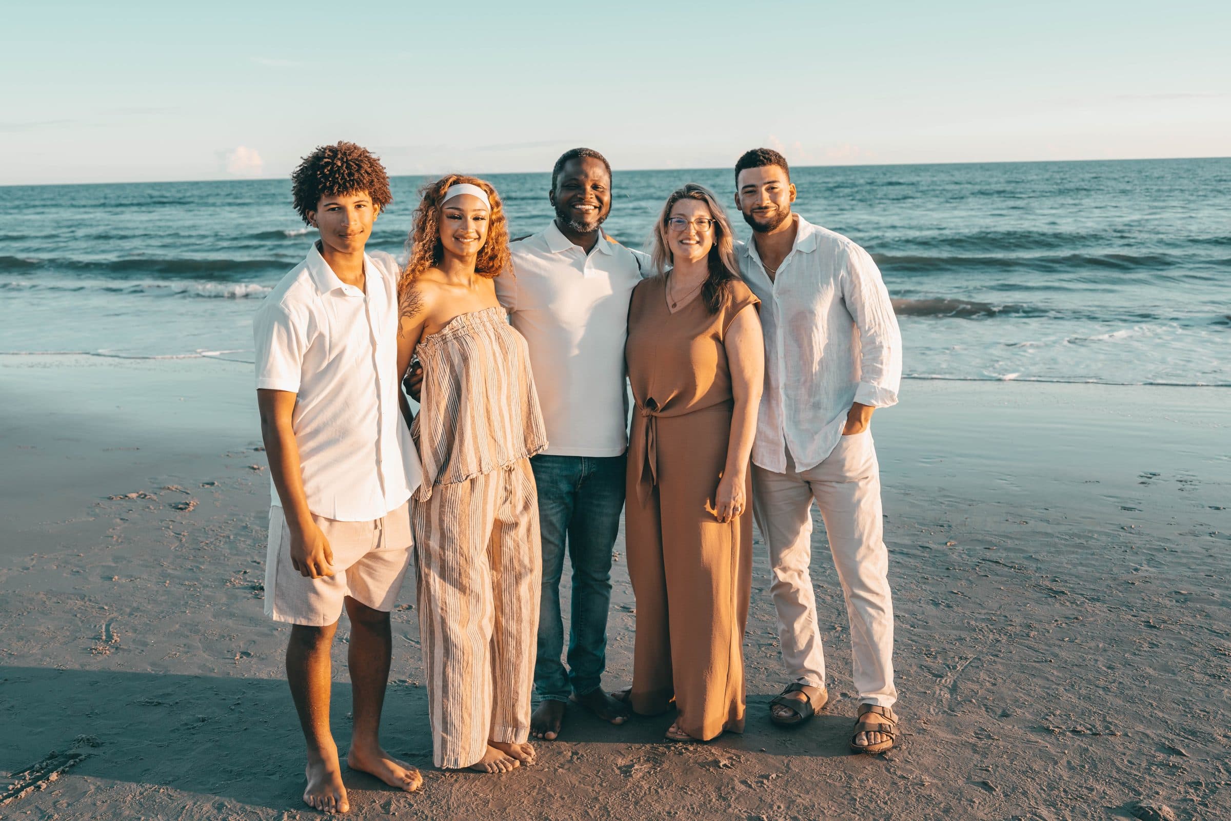 Family of five standing together on the beach