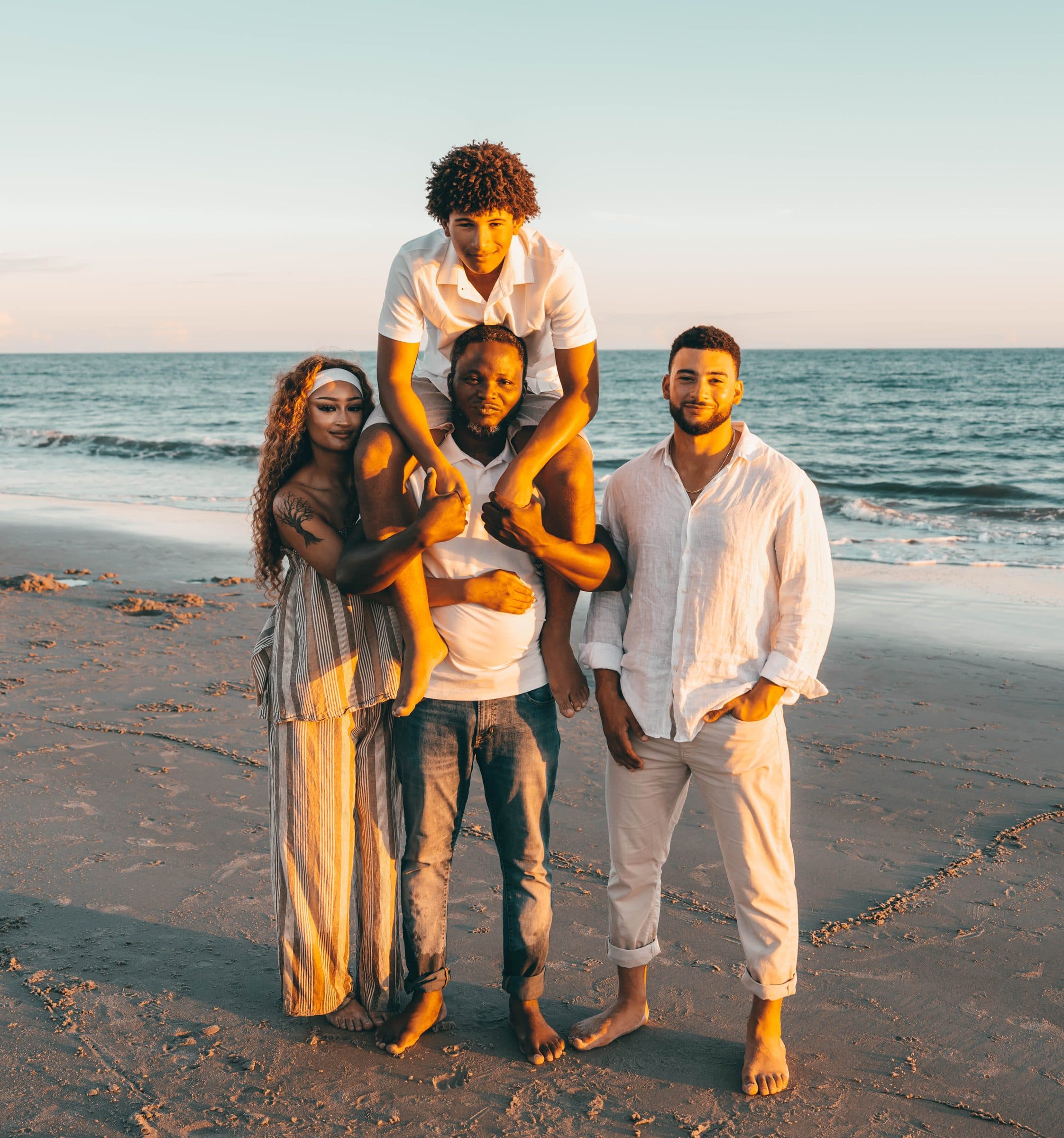 Family portrait with a teenager lifted onto dad's shoulders