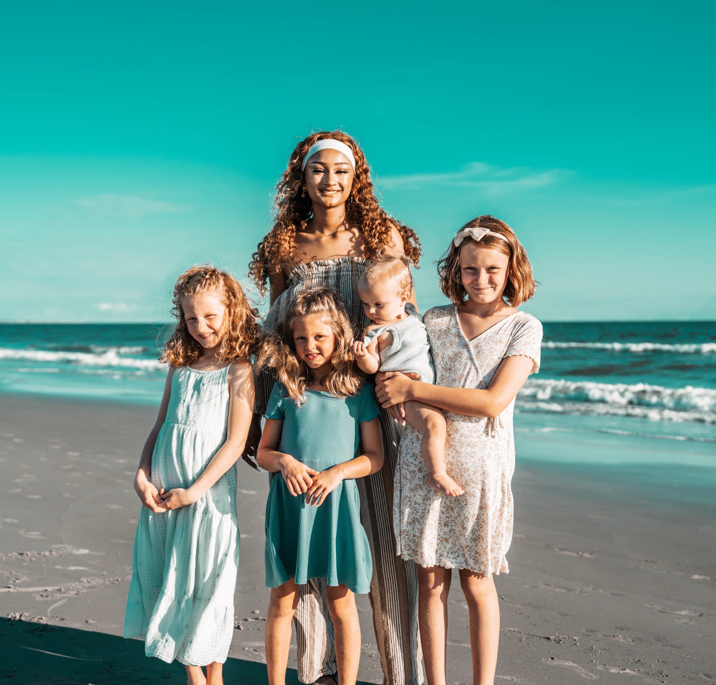 Mom with her kids and baby on the beach