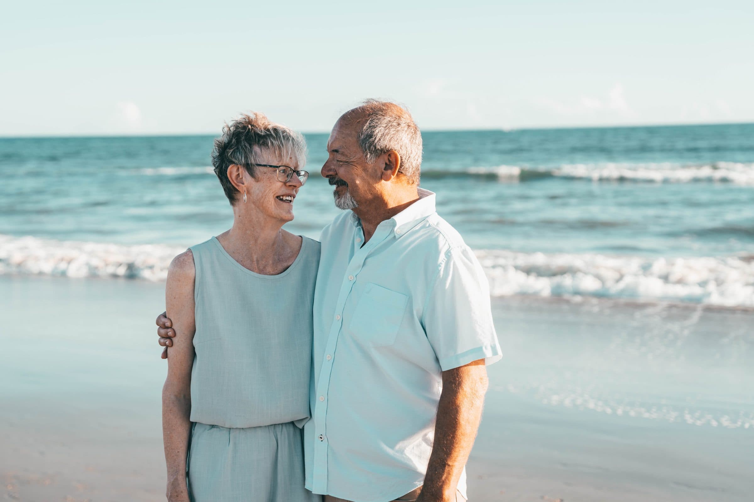 Grandparents laughing together at the water's edge