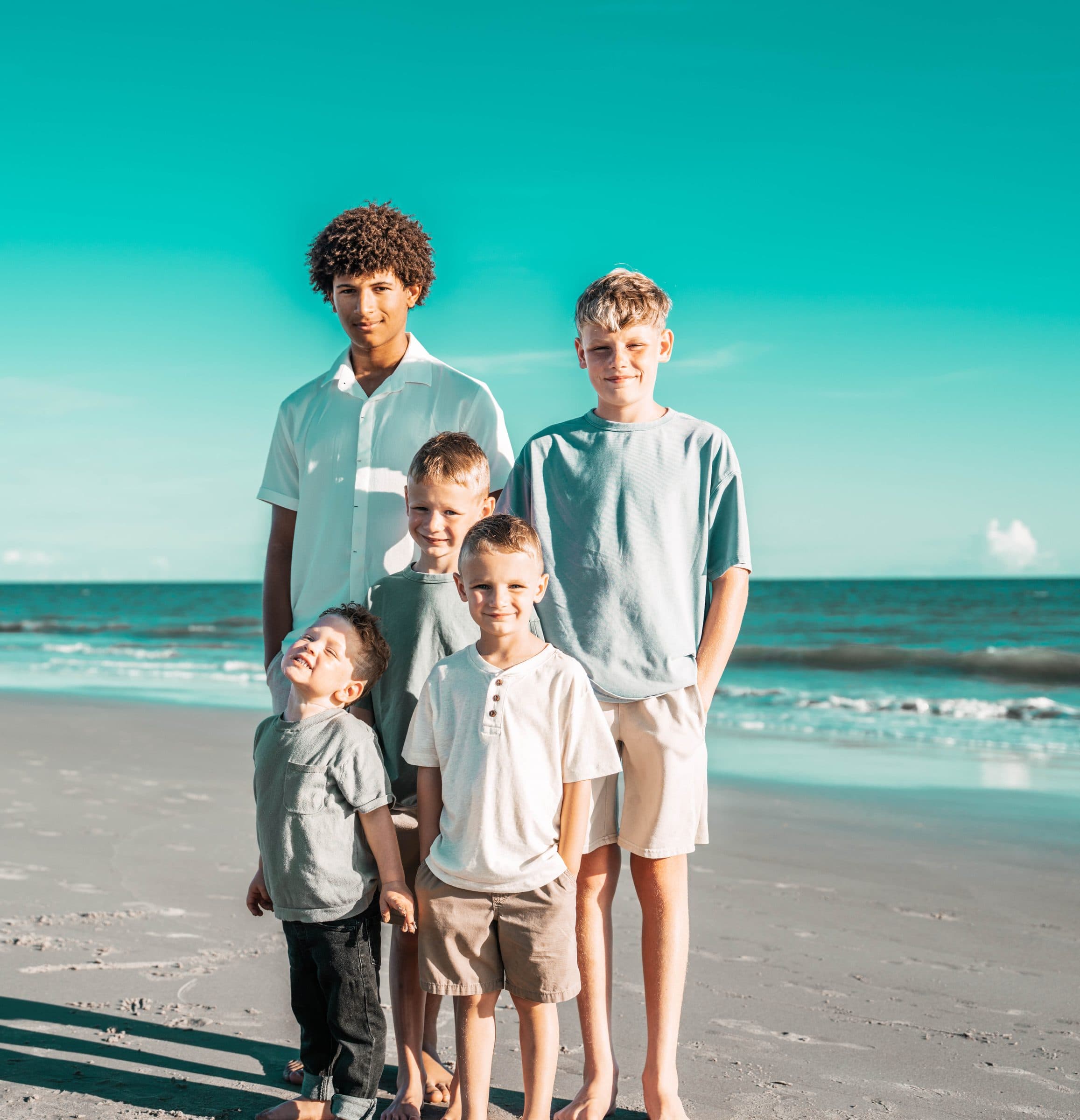 Brothers and cousins standing together by the ocean