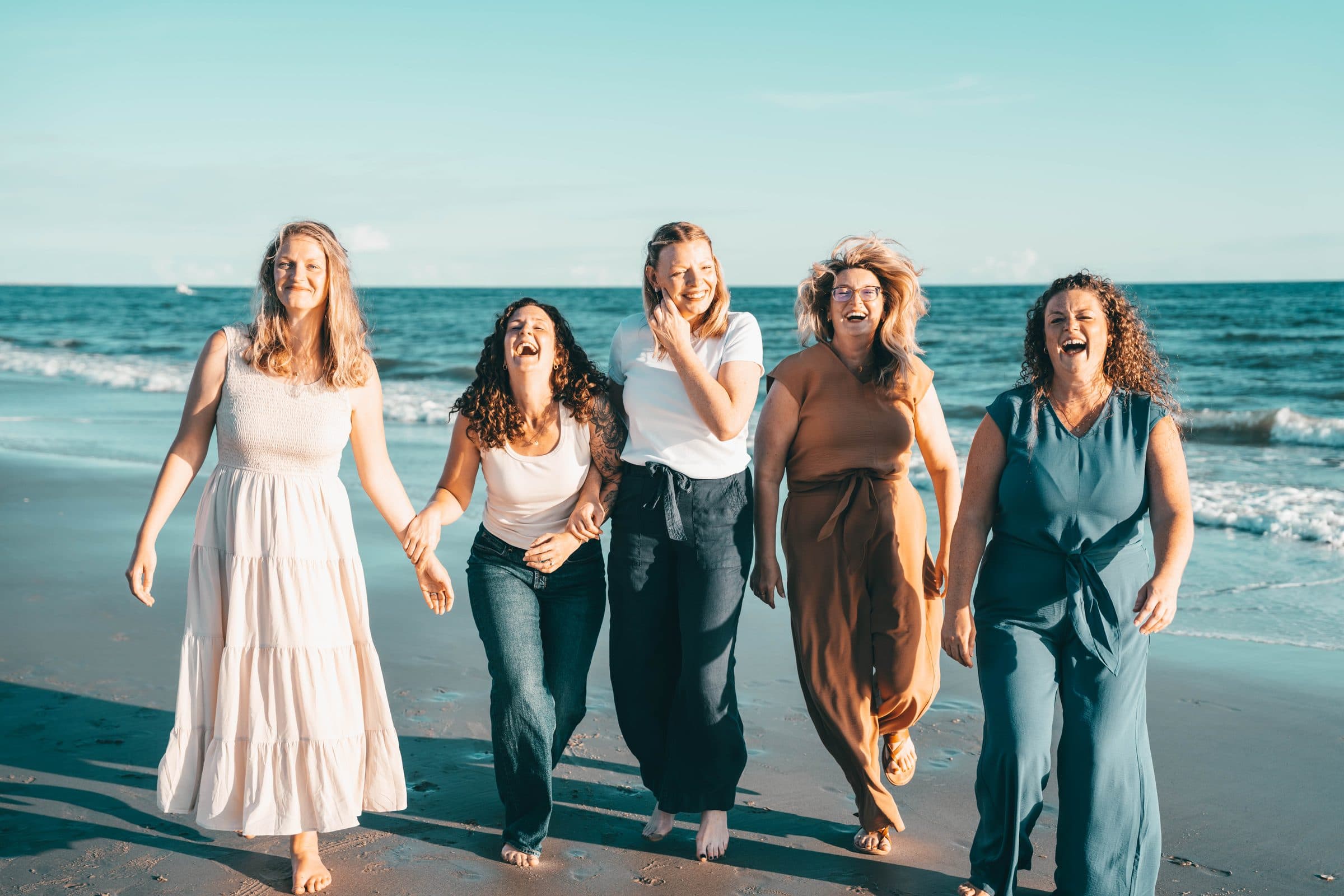 Sisters walking and laughing along the shoreline